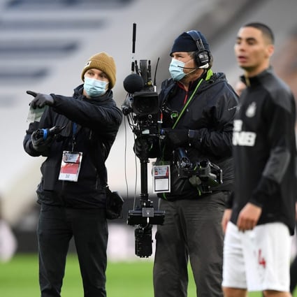 TV camera operators, wearing a face mask or covering due to the Covid-19 pandemic, work as players warm up ahead of the English Premier League football match between Wolverhampton Wanderers and Newcastle United. Photo: AFP