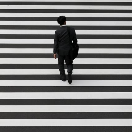 A businessman crosses a road in Tokyo’s business district in October 2015. Since the early 1990s, Japan has battled deflation. Photo: Reuters