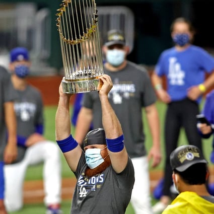 A masked Justin Turner celebrates with the Commissioner’s Trophy after the Los Angeles Dodgers beat the Tampa Bay Rays to win the World Series. Photo: USA TODAY Sports