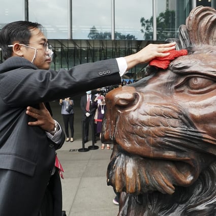 A staff member cleans one of HSBC’s historic lion sculptures ahead of their unveiling outside the bank’s headquarters in Central on October 22. The sculptures were restored after suffering damage during last year’s protests. HSBC has come under increased scrutiny of late amid US sanctions and fears that China might place it on an “unreliable entities” list. Photo: Felix Wong