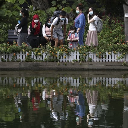 Visitors keep their masks on in Hong Kong Park in Admiralty. Hong Kong will allow six people to sit together in restaurants, but still bans public gatherings of more than four. Photo: Jonathan Wong