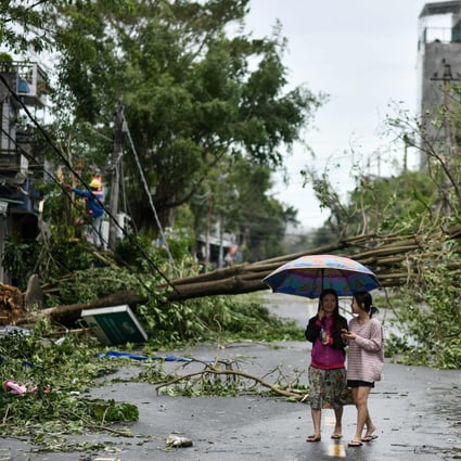 Women walk past uprooted trees in central Vietnam’s Quang Ngai province in the aftermath of Typhoon Molave. Photo: AFP