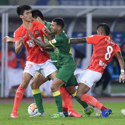 Johnathan Viera (centre) of Beijing Guoan vies for the ball during the play-off match between Beijing Guoan and Guangzhou Evergrande. Photo: Xinhua