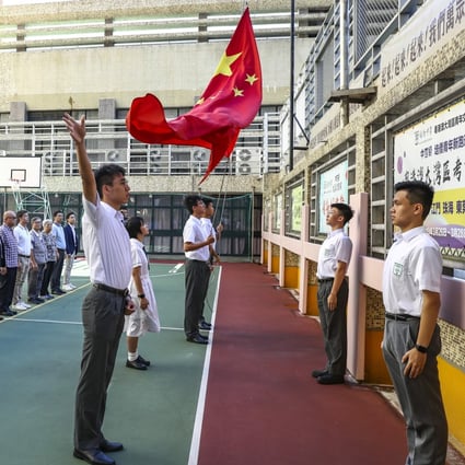 Students from Pui Kiu Middle School in North Point take part in a flag-raising ceremony. Photo: Nora Tam