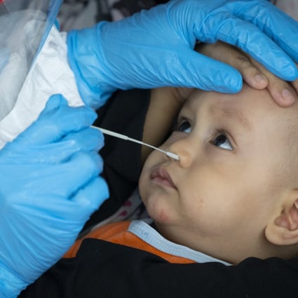 A doctor collects a sample for a coronavirus test from a baby in Subang on the outskirts of Kuala Lumpur, Malaysia on Thursday. Photo: AP