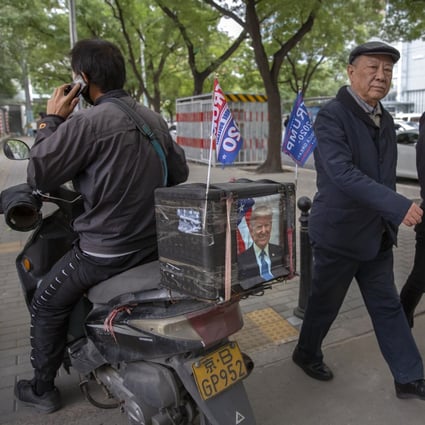A delivery courier rides a motorbike decorated with a portrait of US President Donald Trump and “Trump 2020” flags in Beijing on October 14. Chinese leaders hope Washington will tone down conflicts over trade, technology and security if Joe Biden wins the presidential election. But any shift is likely to be in style, not substance, as frustration with Beijing increases across the American political spectrum. Photo: AP
