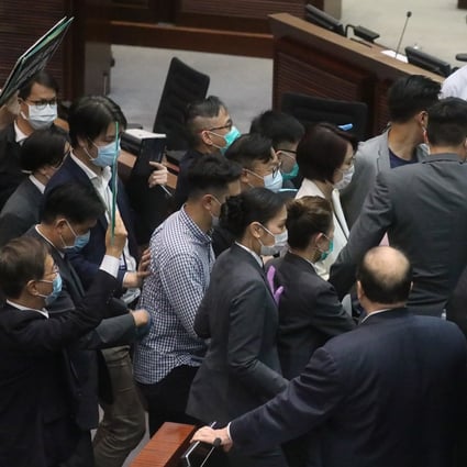 Chairwoman of the House Committee DAB Lawmaker Starry Lee Wai-king (centre in white) leaves the chamber surrounded by security guards, during a Legislative Council meeting. Photo: Dickson Lee