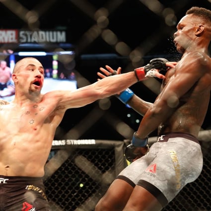 Robert Whittaker punches Israel Adesanya during their middleweight title bout at UFC 243 in Melbourne. Photo: AFP