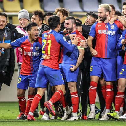 Qingdao Huanghai players celebrate after beating Wuhan Zall in a penalty shoot-out to avoid relegation in the Chinese Super League. Photo: Xinhua