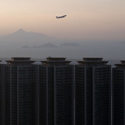 A plane takes off from Hong Kong International Airport with residential buildings in Tung Chung in the foreground. Photo: AFP