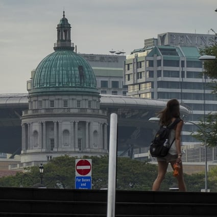 A woman walks as the Supreme Court of Singapore is seen in the background. Photo: Roy Issa