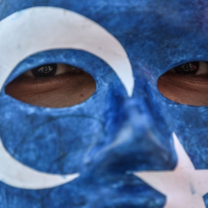 A protester in Istanbul wears a mask with the colours of the East Turkestan flag in 2018. ETIM is seeking an independent Islamic state in Xinjiang called East Turkestan. Photo: AFP