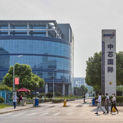People walk past the front entrance of the headquarters of Chinese chip foundry Semiconductor Manufacturing International Corp in Shanghai. Photo: EPA-EFE