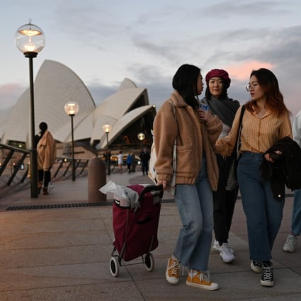 International students from China walk in front of the Sydney Opera House. There are already over 210,000 fewer foreign students in Australia, and this number is expected to increase by the middle of next year. Photo: Reuters