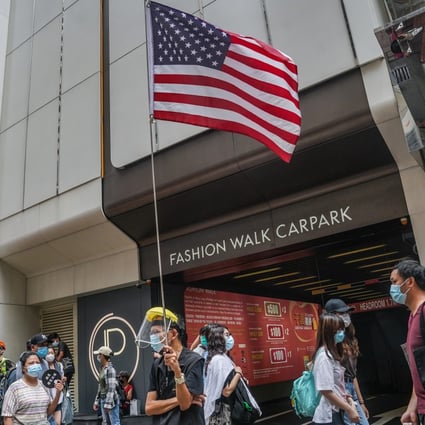 A demonstrator holds a US flag during a protest in Hong Kong on July 1, 2020. Photo: Bloomberg