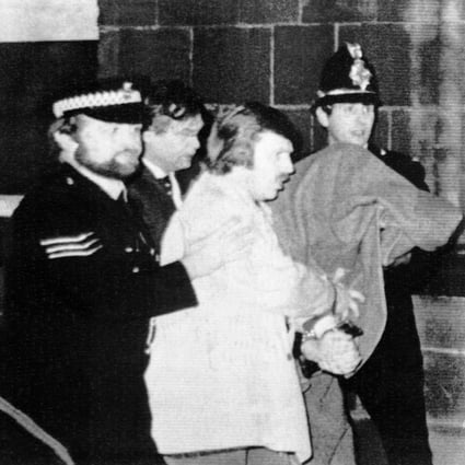 Peter Sutcliffe under a blanket at right being led from Dewsbury Magistrates Court in Dewsbury by police officers in 1981. Photo: AP
