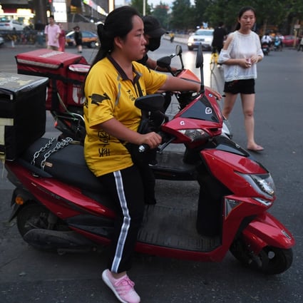 A Meituan delivery rider waits at an intersection in Beijing. Photo: AFP