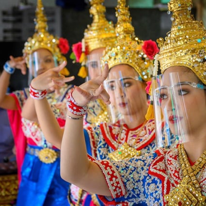 Traditional Thai dancers wearing protective face shields perform at the Erawan Shrine in Bangkok, a major tourist destination. As Thailand’s tourism sector has taken a financial hit from the coronavirus pandemic, the government has been trying to shore up trade ties with other countries to make up for lost revenue. Photo: AFP