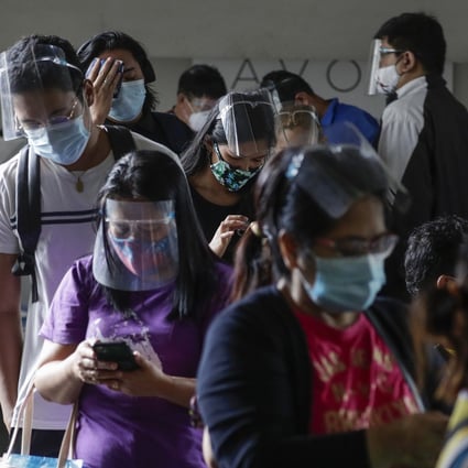 Filipinos in personal protective gear wait to enter a government office in Quezon City. The country has recorded more than 400,000 cases of the coronavirus. Photo: AP