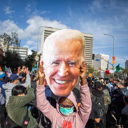 A woman holds a Joe Biden mask as people march in celebration in Los Angeles after he was declared the winner of the presidential election, on November 7. Photo: AFP
