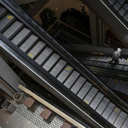 An elderly man wearing a protective mask rides an escalator inside an empty shopping centre in Quezon City, Manila in May during a lockdown. Photo: AP