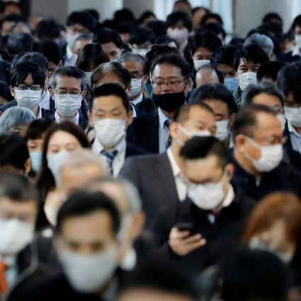 Office workers wearing face masks are seen at Shinagawa station in Tokyo, as the Japanese capital battles an outbreak in Covid-19 cases. Photo: Reuters