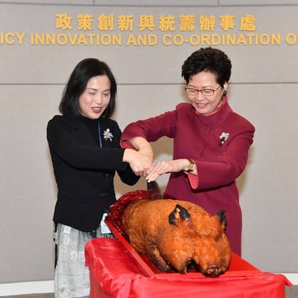 Betty Fung and Carrie Lam cut a roast pig to mark the 2018 opening of the Policy Innovation and Coordination Office, which Fung leads. Photo: Facebook
