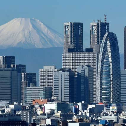 Japan's highest mountain, Mount Fuji, seen in the distance behind the skyline of the Shinjuku area of Tokyo. Photo: AFP