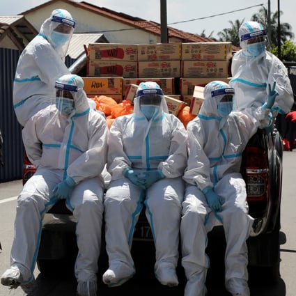 Members of Malaysia Social Welfare Department wearing personal protective equipment prepare for food distribution at an area under enhanced lockdown. Photo: Reuters