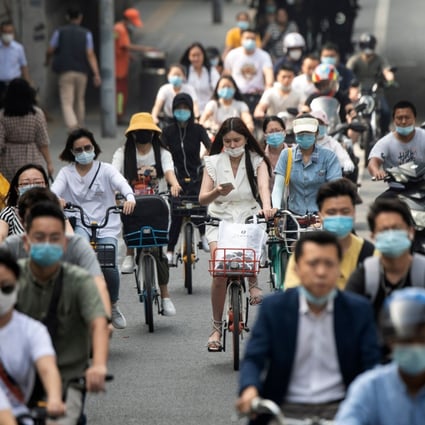 A woman checks her phone among cyclists on a busy street in Beijing on July 20. A growing number of Chinese people are unmarried. Photo: AFP