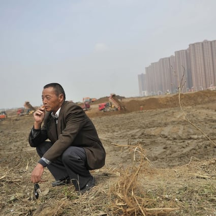 A farmer smokes as some buildings on his land are demolished to make way for the construction of new urban property in Hefei, southeast Anhui province. Land reform remains an important issue on the mainland, one for which Hong Kong’s legal system can provide a template. Photo: Reuters