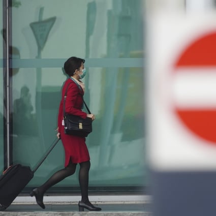 A Cathay Pacific employee wheels her luggage towards an entrance to the company’s headquarters in Chek Lap Kok on October 22. Photo: Sam Tsang