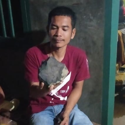 Josua Hutagalung and the meteorite that crashed into his house in North Sumatra. Photo: Handout