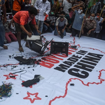 Demonstrators break up Chinese-made goods on a banner with an inscription reading “Boycott Made in China” before burning them during an anti-China demonstration in Kolkata on June 18. Photo: AFP