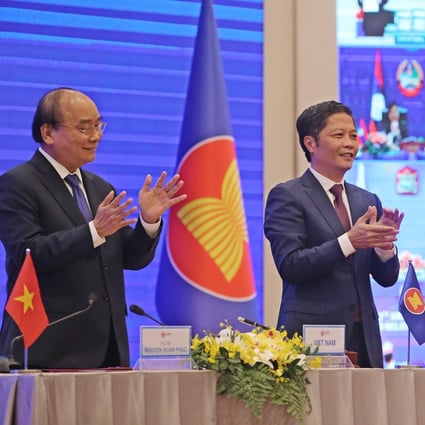 Vietnam’s Prime Minister Nguyen Xuan Phuc (left) and Minister of Industry and Trade Tran Tuan Anh celebrate during the virtual signing ceremony for the Regional Comprehensive Economic Partnership in Hanoi on November 15. Photo: EPA-EFE