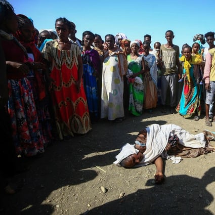 Ethiopian refugees who fled fighting in the Tigray region stand around a woman who collapsed at the Village 8 border reception centre in Sudan’s eastern Gedaref state. Photo: AFP