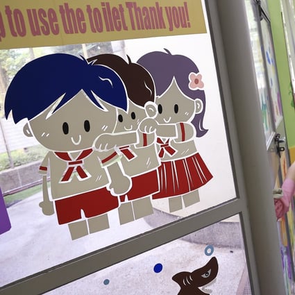 A cleaning worker wipes down the doors and windows at a kindergarten in Tung Chung on November 17, after the government announced the suspension of face-to-face teaching at all kindergartens and daycare centres amid an outbreak of upper respiratory tract infections. Photo: May Tse