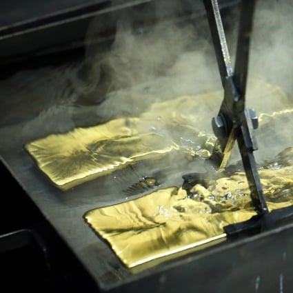 A worker plunges a gold ingot into a cooling bath at the Uralelectromed Copper Refinery, operated by Ural Mining and Metallurgical Co. (UMMC), in Verkhnyaya Pyshma, Russia on July 30, 2020. Photo: Bloomberg