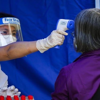 A medical worker takes the temperature of a resident at a temporary Covid-19 testing station outside Fu Shin Community Hall in Tai Po on November 9. Photo: Sam Tsang