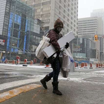 A shopper carries Christmas purchases in Toronto a day before coronavirus restrictions are reintroduced. Photo: Reuters