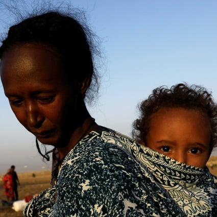 An Ethiopian refugee carries her child near the Setit river on the Sudan-Ethiopia border in Hamdayet village in eastern Kassala state. Photo: Reuters