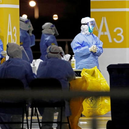 Workers in protective suits staff a makeshift nucleic acid testing site inside a car park at Shanghai Pudong International Airport on Sunday. Photo: CNS Photo via Reuters