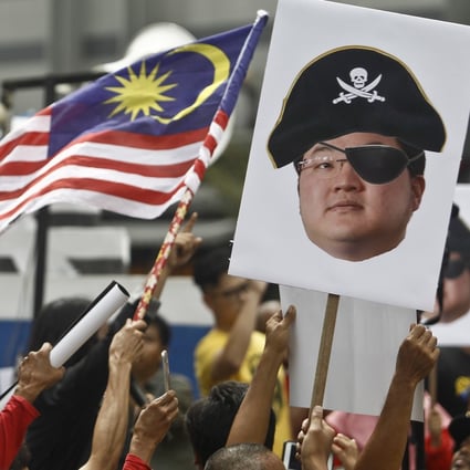 Protesters hold portraits of Jho Low illustrated as a pirate during a rally in Kuala Lumpur, Malaysia, in 2018. Photo: AP