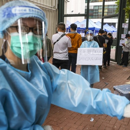 A health worker directs people from dancing groups to a queue at a temporary screening venue in Hong Kong. Photo: Nora Tam