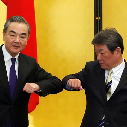 China’s Foreign Minister Wang Yi and his Japanese counterpart Toshimitsu Motegi bump elbows at the start of their talks in Tokyo on Tuesday. Photo: Reuters