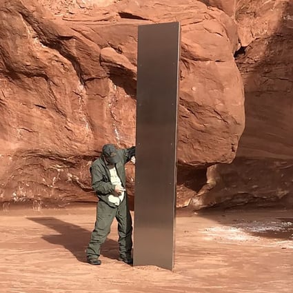 A state worker inspects a metal monolith that was found installed in the ground in a remote area of red rock in Utah on November 18. Photo: Utah Department of Public Safety handout via AP