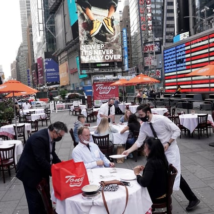 Servers deliver food to a table at a pop-up restaurant set up in Times Square in New York on October 23. Consumer spending accounts for 68 per cent of the US economy. But with Covid-19 still raging, services consumption – restaurant dining, in-person shopping, travel – is unlikely to recover soon. Photo: Reuters