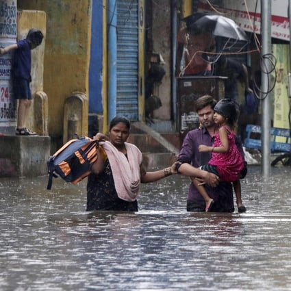 A family wades through a flooded street after Cyclone Nivar made landfall in India’s southern state of Tamil Nadu. Photo: AP