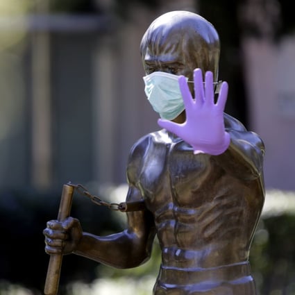 A picture taken on April 2, 2020, shows the Mostar statue dedicated to martial arts icon and actor Bruce Lee, wearing surgical gloves and a face mask. Photo: AFP
