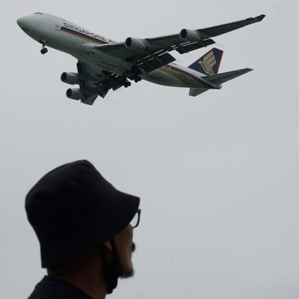 A man looks on as a Singapore Airlines plane approaches for landing at Changi International Airport earlier this year. Photo: AFP